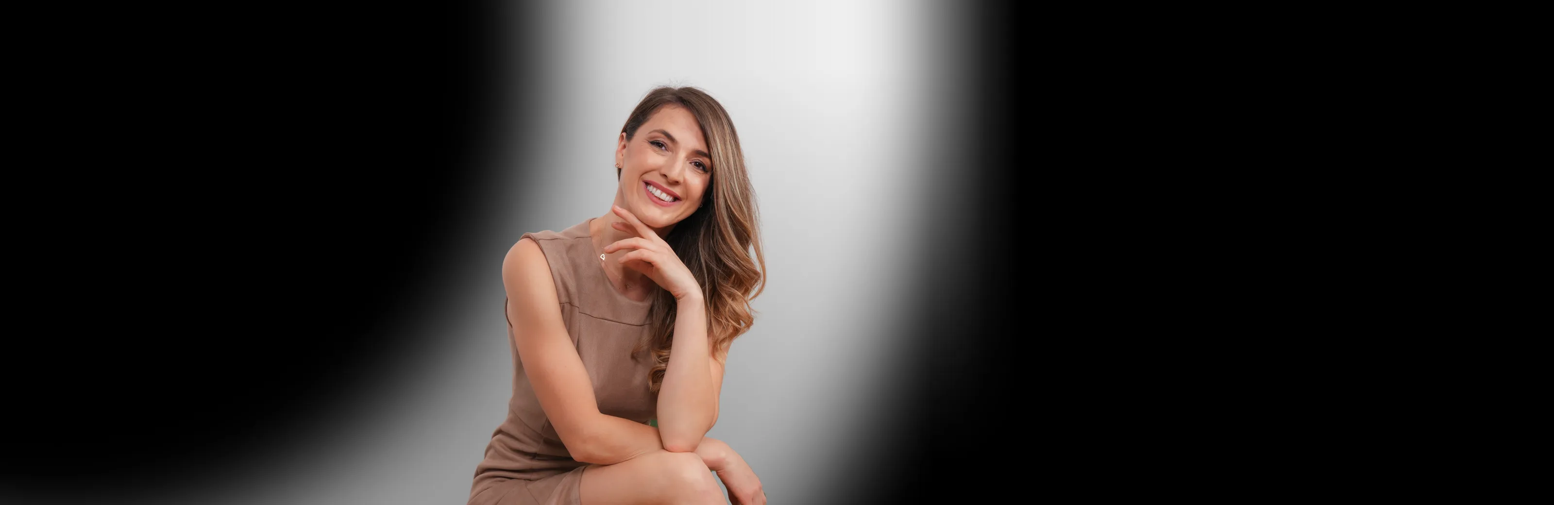Andreea Giurgilă, life coach și NLP Master Coach, zâmbind, cu mâna sub bărbie